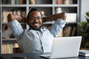 Adult male sitting at desk with laptop